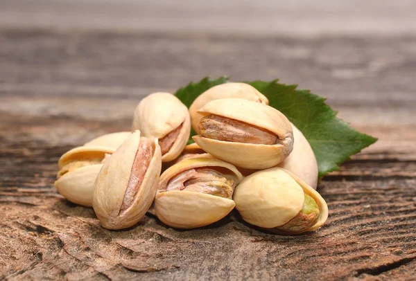 Roasted pistachios on wooden background — Stock Photo, Image