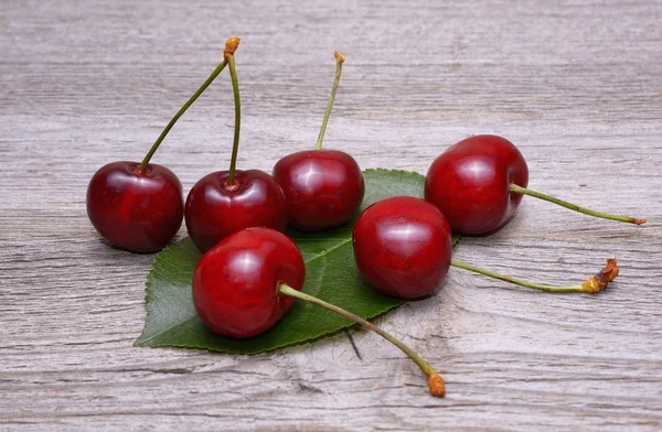 Cerezas sobre mesa de madera — Foto de Stock