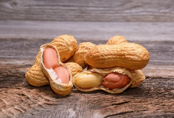 Erdnüsse in Schalen auf Holz Hintergrund — Stockfoto