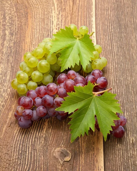 Raisins avec feuilles sur table en bois — Photo