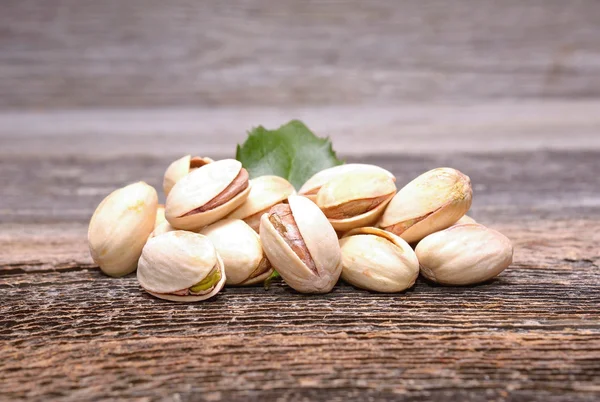 Roasted pistachios on wooden background — Stock Photo, Image