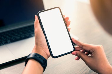 Masada boş bir beyaz ekran akıllı telefon ve dizüstü bilgisayar var. Reklamcılığın reklamını yapmak için..