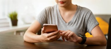 Akıllı telefon tutan ve internetten sosyal medya kullanan bir kadın..