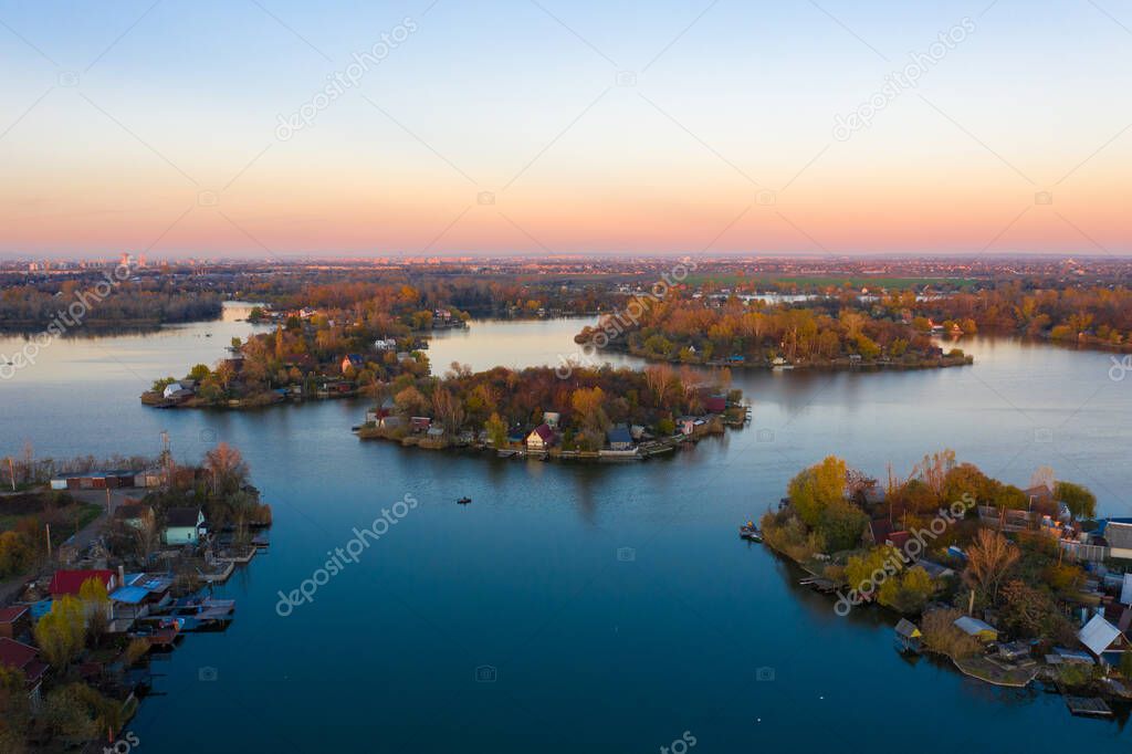 Szigetszentmiklos, Hungary - Aerial drone view of a tiny fishing islands on Lake Kavicsos (Kavicsos to) near Budapest. The islands are full with fishing huts, piers and cabins. Warm autumn colors.
