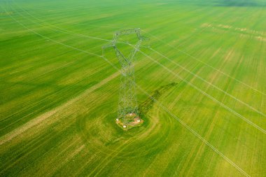 Elektrik pilonunun hava yakın görüntüsü tarımsal alan üzerinde elektrik hatları var..