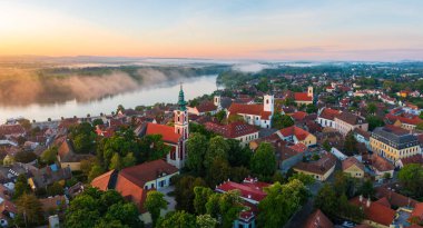 Splendid foggy sunrise over Szentendre, Hungary with river Danube at the background. Panoramic cityscape.