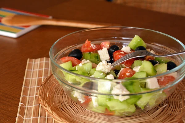 Salada de legumes fresca misturada com pedaços de queijo em uma tigela de vidro — Fotografia de Stock