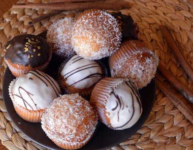 Bir plaka üzerinde çikolata ve rendelenmiş hindistan cevizi ile lezzetli ev yapımı vanilyalı kek.