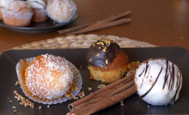 Bir plaka üzerinde çikolata ve rendelenmiş hindistan cevizi ile lezzetli ev yapımı vanilyalı kek.