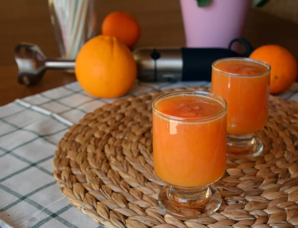 Dos vasos de pomelo fresco, naranja y papaya batido en una mesa de madera. Primer plano. . —  Fotos de Stock