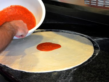 Pizzaya temel yayıldığını domates sosu.