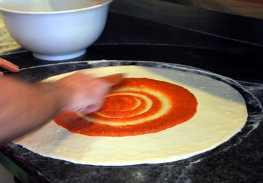 Pizzaya temel yayıldığını domates sosu.