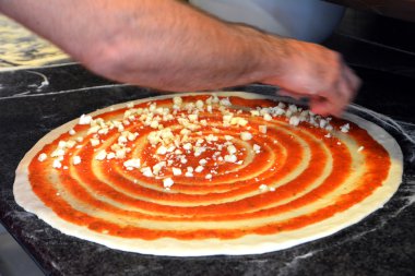 Adamın elini bir İtalyan pizza peyniri ile hazırlanıyor 