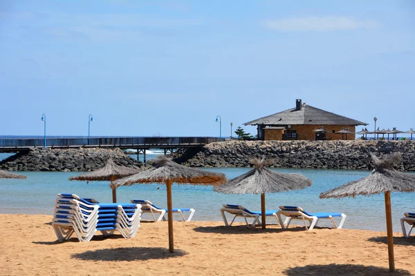 Scene with two deck chairs and umbrella on a tropical beach. — Stock Photo, Image