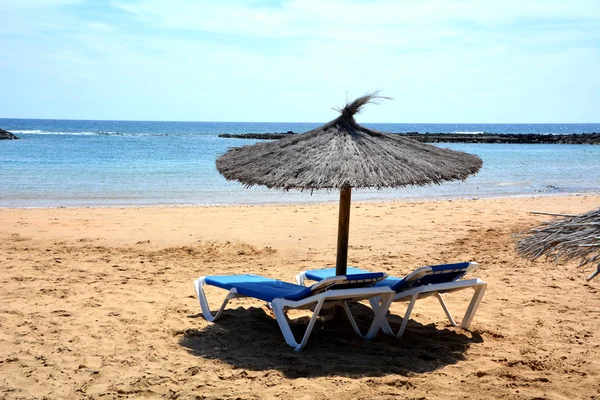 Scene with two deck chairs and umbrella on a tropical beach. — Stock Photo, Image