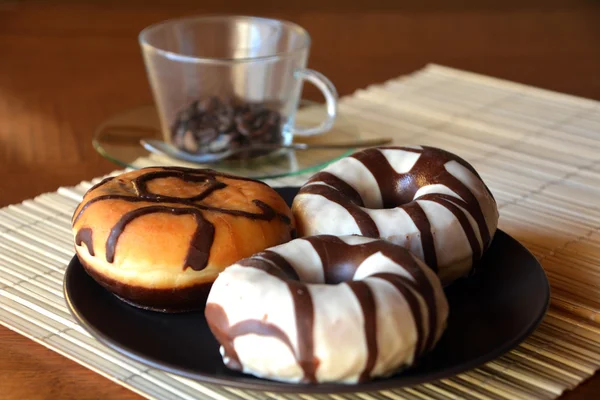 Las rosquillas tradicionales con el chocolate castaño en el plato a la mesa — Foto de Stock