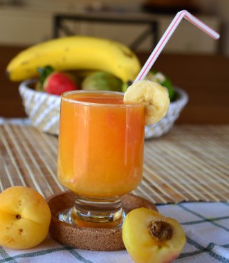 Portakal, muz ve kayısı bir cam ile sağlıklı taze yüzlü