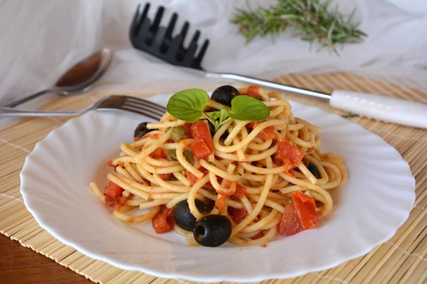 Spaghetti a la puttanesca op een kom. Italiaans eten. — Stockfoto