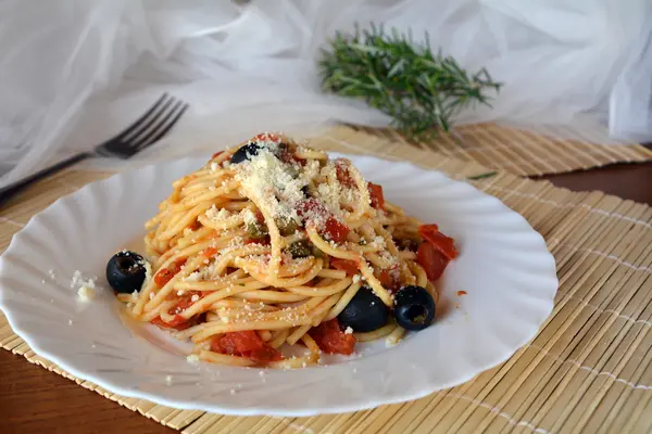 アラカルト ボウルについてのプッタネスカ スパゲティ。イタリア料理. — ストック写真