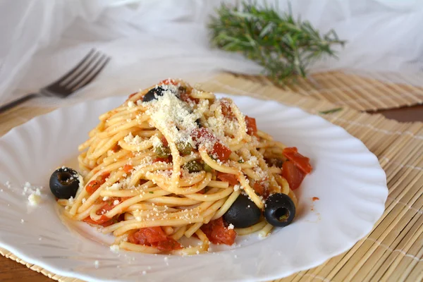 アラカルト ボウルについてのプッタネスカ スパゲティ。イタリア料理. — ストック写真