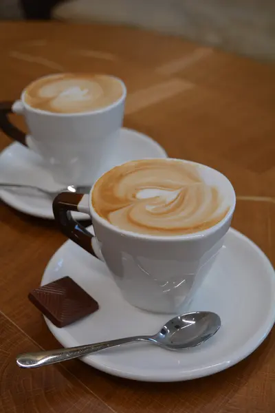 Copa de capuchino espumoso sobre una mesa de madera — Foto de Stock