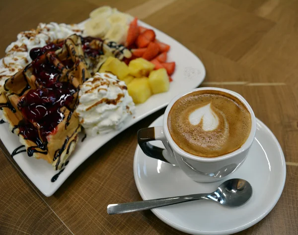 Waffles com frutas e chantilly e xícara de cappuccino — Fotografia de Stock