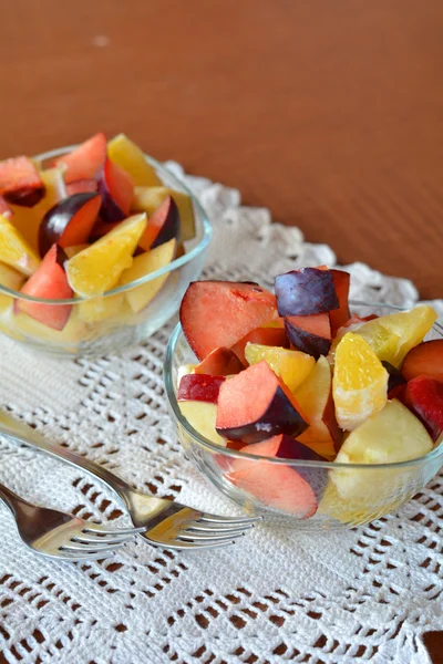 Mixed fruit salad in the bowl on the wooden table — Stock Photo, Image