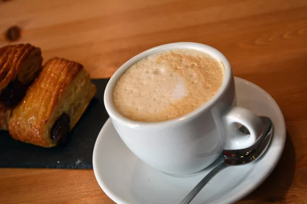 Csésze forró cappuccino és a fából készült asztal kis pizza — Stock Fotó