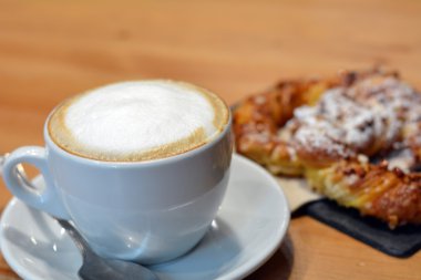 Ahşap masa üzerinde beyaz fincan lezzetli kapuçino