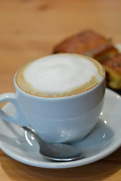 Delicious cappuccino in white cup on the wooden table — Stock Photo, Image