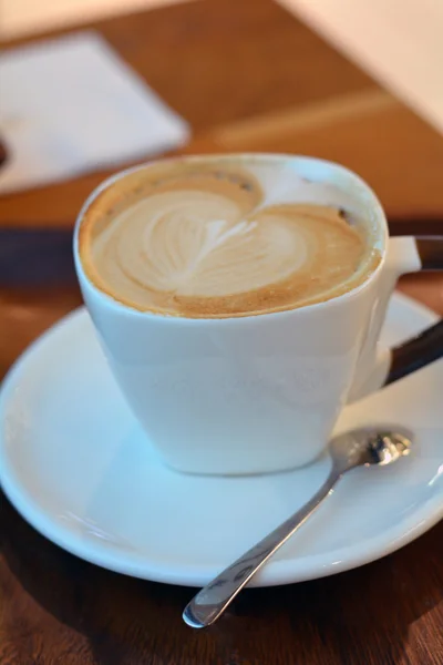 Köstlicher Cappuccino in weißer Tasse auf dem Holztisch — Stockfoto