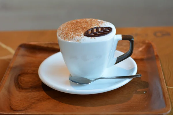 Cup of cappuccino in white cup on the wooden table — Stock Photo, Image