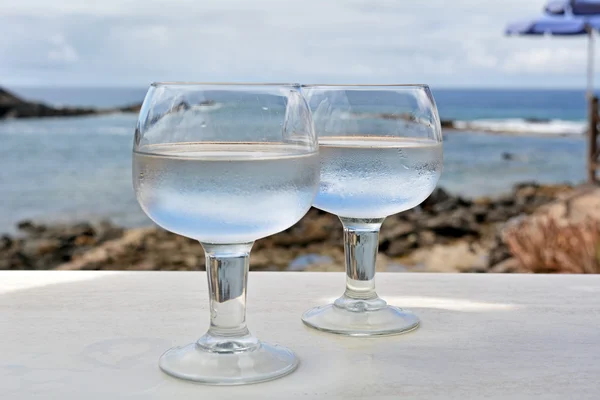 Celebração com dois copos com fundo do mar — Fotografia de Stock