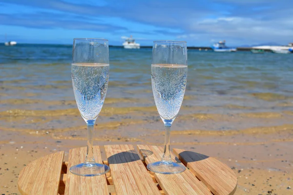 Feest met twee glazen van champagne op het paradijs strand — Stockfoto