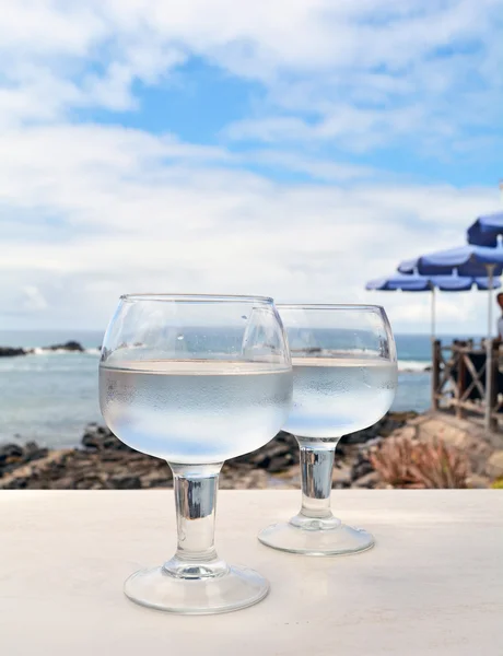 Celebração com dois copos com fundo do mar — Fotografia de Stock