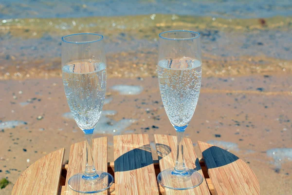 Feest met twee glazen van champagne op het paradijs strand — Stockfoto
