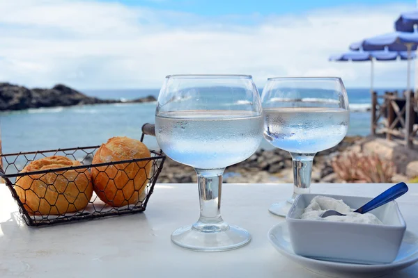 Dois copos de água na mesa com fundo do mar — Fotografia de Stock