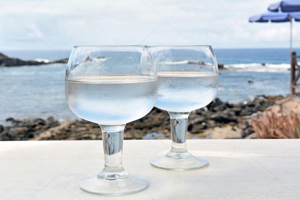 Two Glasses Of Watter on The Table With Sea Background