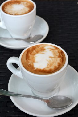 Siyah arka plan üzerine lezzetli sıcak cappuccino