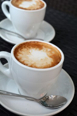 Siyah arka plan üzerine lezzetli sıcak cappuccino