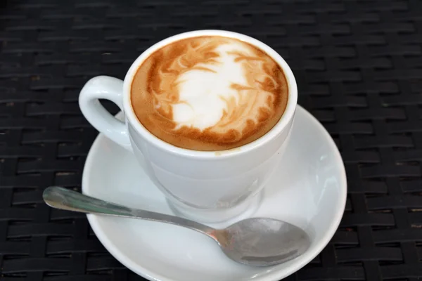 Pyszne cappuccino gorącą na czarnym tle — Zdjęcie stockowe