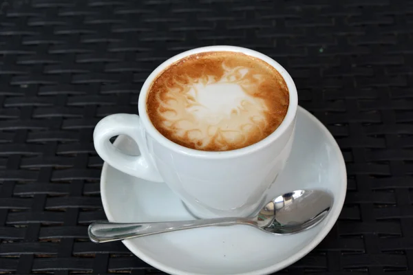 Delicioso capuchino caliente sobre el fondo negro — Foto de Stock