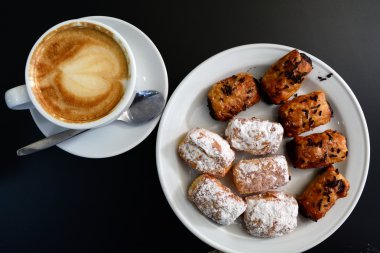 Fincan kapuçino ve siyah arka plan üzerine pasta