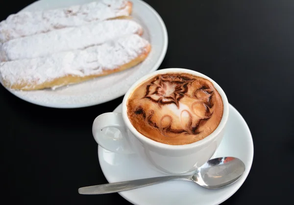 杯卡布奇诺咖啡和蛋糕的黑色背景 — 图库照片
