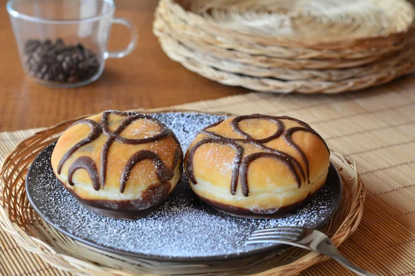 Traditioneller Donut mit Schokolade auf dem braunen Teller auf dem Tisch — Stockfoto