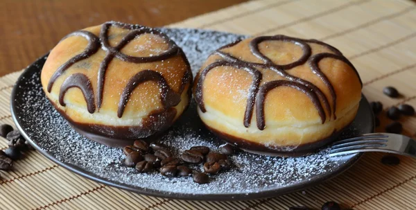 Donuts mit Puderzucker und Schokolade auf dem braunen Teller — Stockfoto