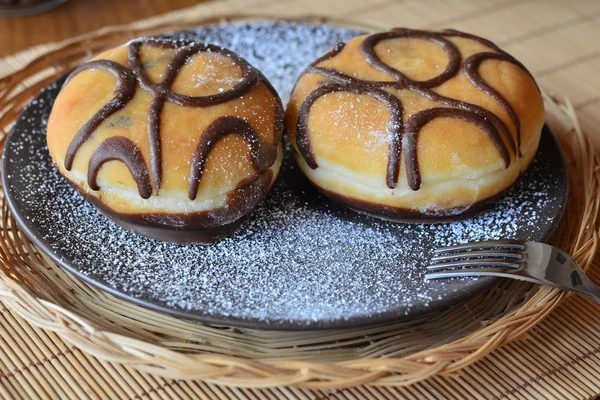 Donuts mit Puderzucker und Schokolade auf dem braunen Teller — Stockfoto