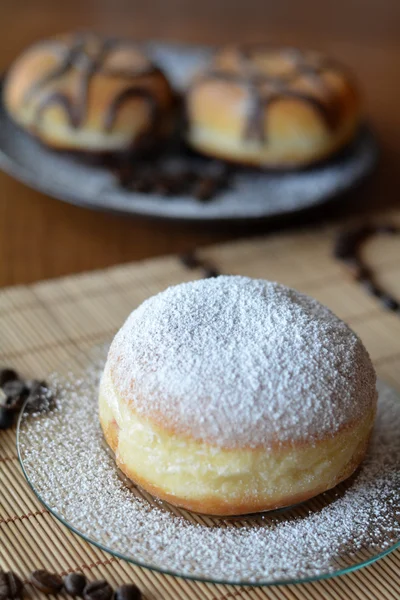 Donuts mit Puderzucker und Schokolade auf dem braunen Teller — Stockfoto
