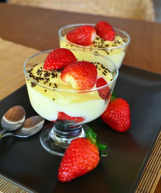Ahşap masa üzerinde taze çilek ile vanilya puding