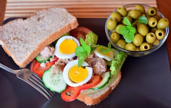 Сэндвич с ржаным хлебом с тунцом, яйцами, помидорами и огурцом — стоковое фото